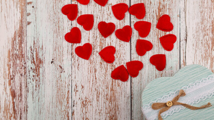Gift box with hearts on a wooden background. Copy space