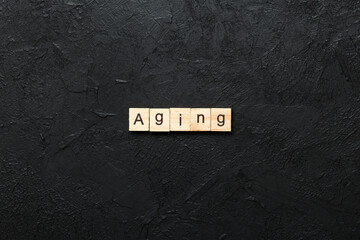 Aging word written on wood block. Aging text on cement table for your desing, concept