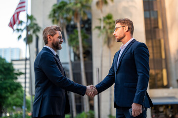 American businessman shaking hands with partner. Two businessmen shaking hands outdoor. Business mens growth strategy. Business men with proposal to the client. Collaborated on a project. - 786940871
