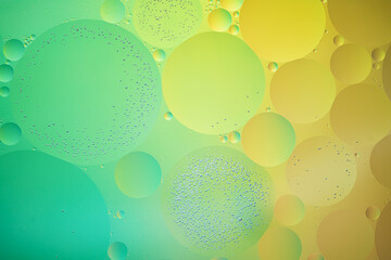 Abstract yellow and green colorful background with oil on water surface. Oil drops in water...