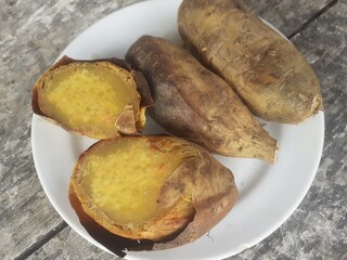 Cilembu sweet potato roasted with honey on a small plate. Wooden table background. Cilembu sweet potato is a local breed of sweet potato cultivar from Cilembu village.