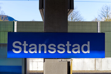 Close-up of blue and white metal sign at railway station of Swiss village of Stansstad on a sunny spring morning. Photo taken April 11th, 2024, Stansstad, Switzerland.