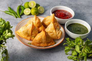 selective focus Samosa, Spiced potato-filled pastry, crispy, Savory, popular Indian snack with tomato and mint chutney. 