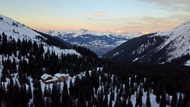 Alpine Lodge at Sunset with Snowy Mountain Backdrop