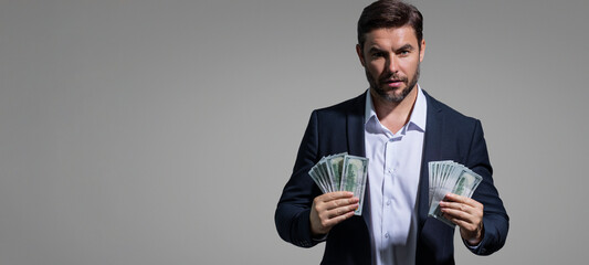 Business man hold money on gray studio isolated background. Rich man in suit with money dollar...