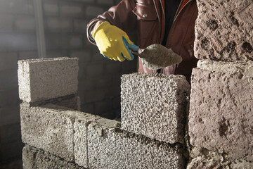 Worker builds a wall in the building site.