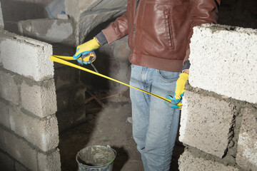 Worker measure concrete wall in a measure tape.