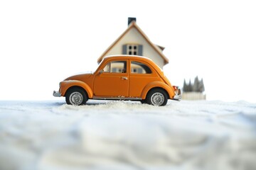 Fototapeta premium Orange toy car parked in front of a house, suitable for real estate concept