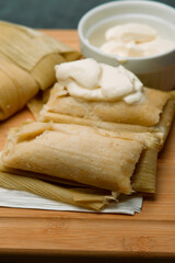 Central American tradition: savory tamales wrapped in corn leaves, served with creamy goodness, a taste of El Salvador