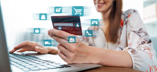 Elegant customer wearing floral shirt holding credit card choose online platform. Smart consumer...