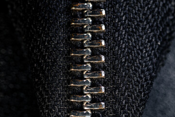 Closed vertical zipper on a black leather bag close-up. Bag zipper in close-up