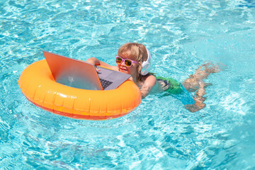 Summer business. Kid working on laptop computer at poolside swimming pool. Summer online technology. Traveler relaxing on tropical sea in summer holidays. - 786958670