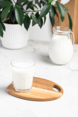 glass and jug of milk in a bright kitchen, dairy products, calcium