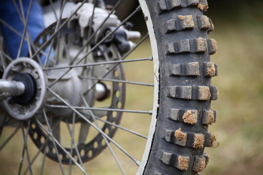 Motocross enduro motor cycle front wheel with rough tire and disc brake closeup