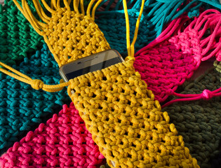 Multi-colored bags for mobile phones on a wooden background.