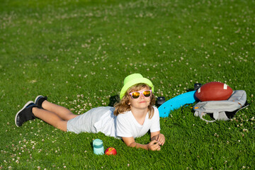 Kid boy girl resting on green grass. Kids playing outdoors in spring park. Freedom and carefree. Happy childhood. Relaxing kid in green field on grass during spring. - 786969041