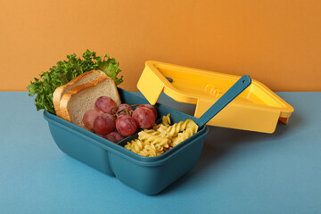 Blue lunch box with food on a blue background - Powered by Adobe