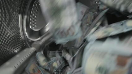 Washing a heap of one hundred dollar bills in washing machine, inside view of drum during spin cycle. Concept of money laundering, financial fraud.