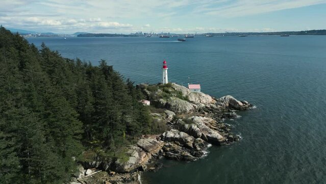 aerial view around point atkinson lighthouse in lighthouse park in west vancouver on an partially cloudy day, british columbia, canada