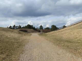 Salduve hill during cloudy day. Small hill. Grass is growing on hill. Staircase leading to the top....