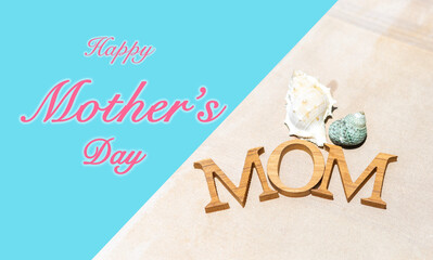 Happy Mother's day logo on blue background with mom wooden text with seashell, summer outdoor day light