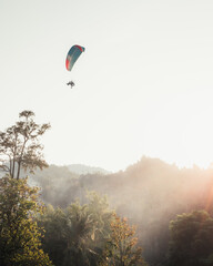 A paraglider in the sky at sunset