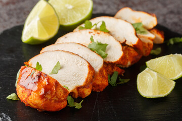 Homemade Grilled Chipotle Chicken Breast with Cilantro and LIme closeup on a slate plate on the...