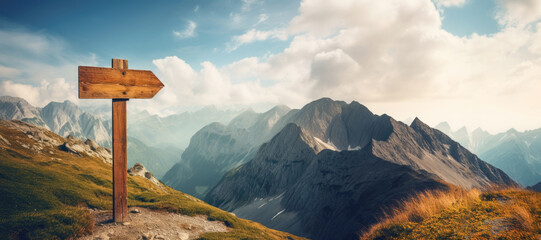 A wooden trail signpost stands amidst a panoramic view of the alpine wilderness, guiding hikers through scenic meadows and rocky terrain. - obrazy, fototapety, plakaty