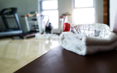 Water and towels on the gym bench