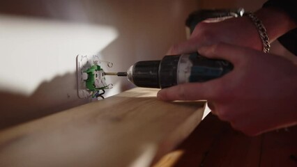 Single socket wall plug mounted to wall above shelf by electrician using drill