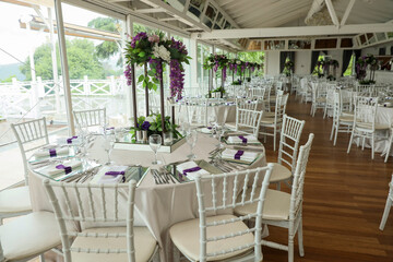 The elegant wedding table ready for guests. Decorated white wedding table for a festive dinner with...