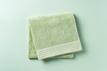 Green towels placed on a green background.