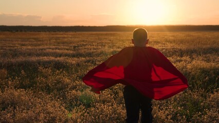 Child superhero in red cape, nature. Active Boy, child plays superhero, sun. Happy run of boy child...