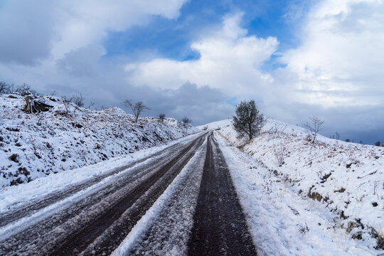 Dans le Finistère, les monts d'Arrée : une route enneigée traverse le paysage, offrant une vue hivernale saisissante.