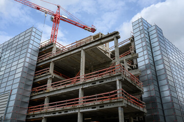 A construction site with a crane and the shell of a house - 787015091