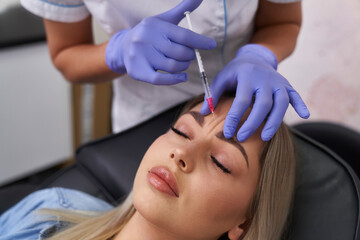 Woman having facelifting procedure in beauty salon