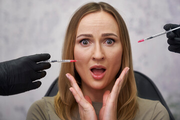 Portrait of shocked woman among syringes - 787018085