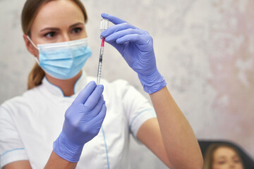 Doctor preparing syringe before beauty procedure - 787018225