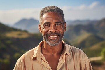 Portrait of a glad afro-american man in his 50s donning a classy polo shirt isolated on panoramic mountain vista - obrazy, fototapety, plakaty