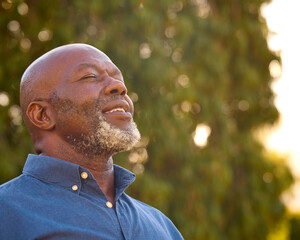Portrait Of Smiling Senior Man Outdoors In Countryside Relaxing Closing Eyes And Taking Deep Breaths