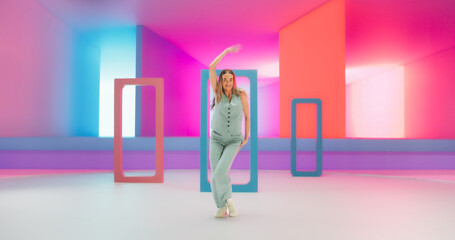 Beautiful Woman with Bright Makeup Dancing Energetically and Interacting with Colorful Geometric Abstract Environment. Creative Young Female Happily Performing Modern Dance Choreography in a Studio
