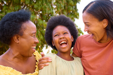 Loving Three Generation Female Family Laughing And Hugging Outdoors In Countryside
