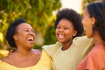 Loving Three Generation Female Family Laughing And Hugging Outdoors In Countryside