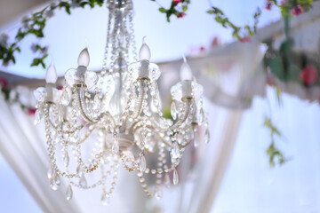 Decoration of outdoor wedding ceremony that setting on the beach by crystal Chandelier 