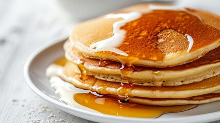 Pancakes with butter and honey syrup on the white plate isolated on a white background