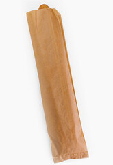 Fresh baguette in brown paper bag on white background