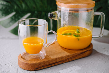 Freshly blended orange smoothie in glass and pitcher