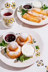 Delicious homemade desserts with berry sauce and cream