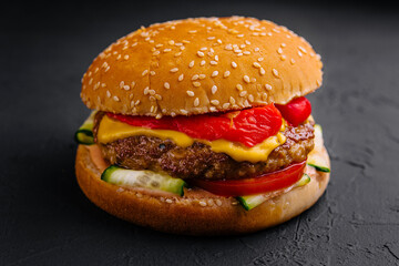 Delightful gourmet cheeseburger on dark background