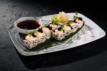 Gourmet sushi roll platter with caviar and soy sauce